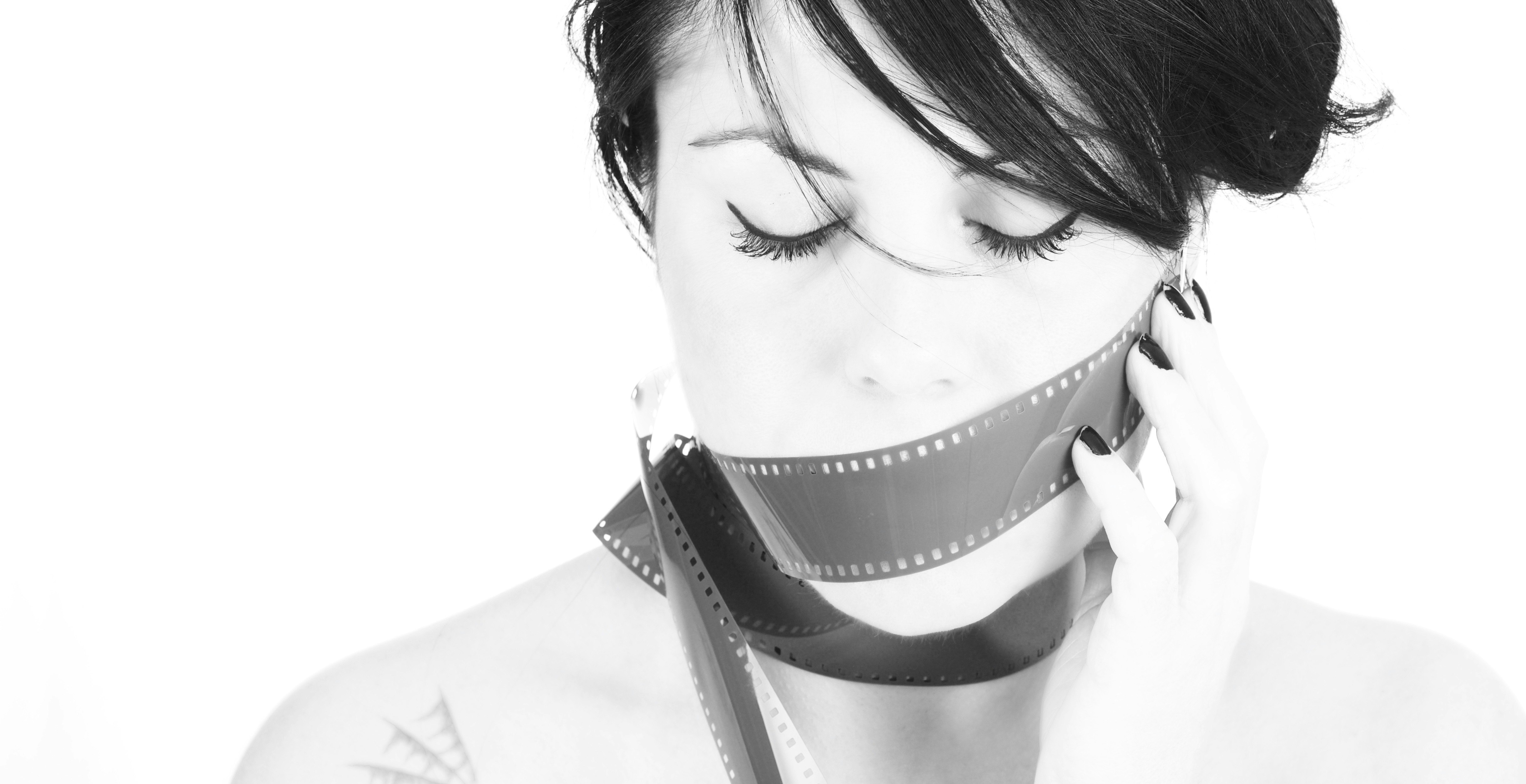 woman covering her mouth with film strip